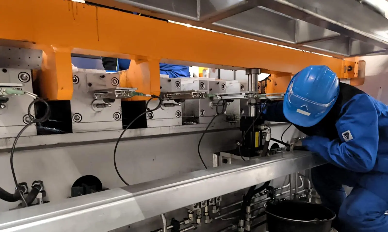 Mitarbeiter von LupenRhein mit Schutzhelm bei Arbeiten an einer Produktionsanlage